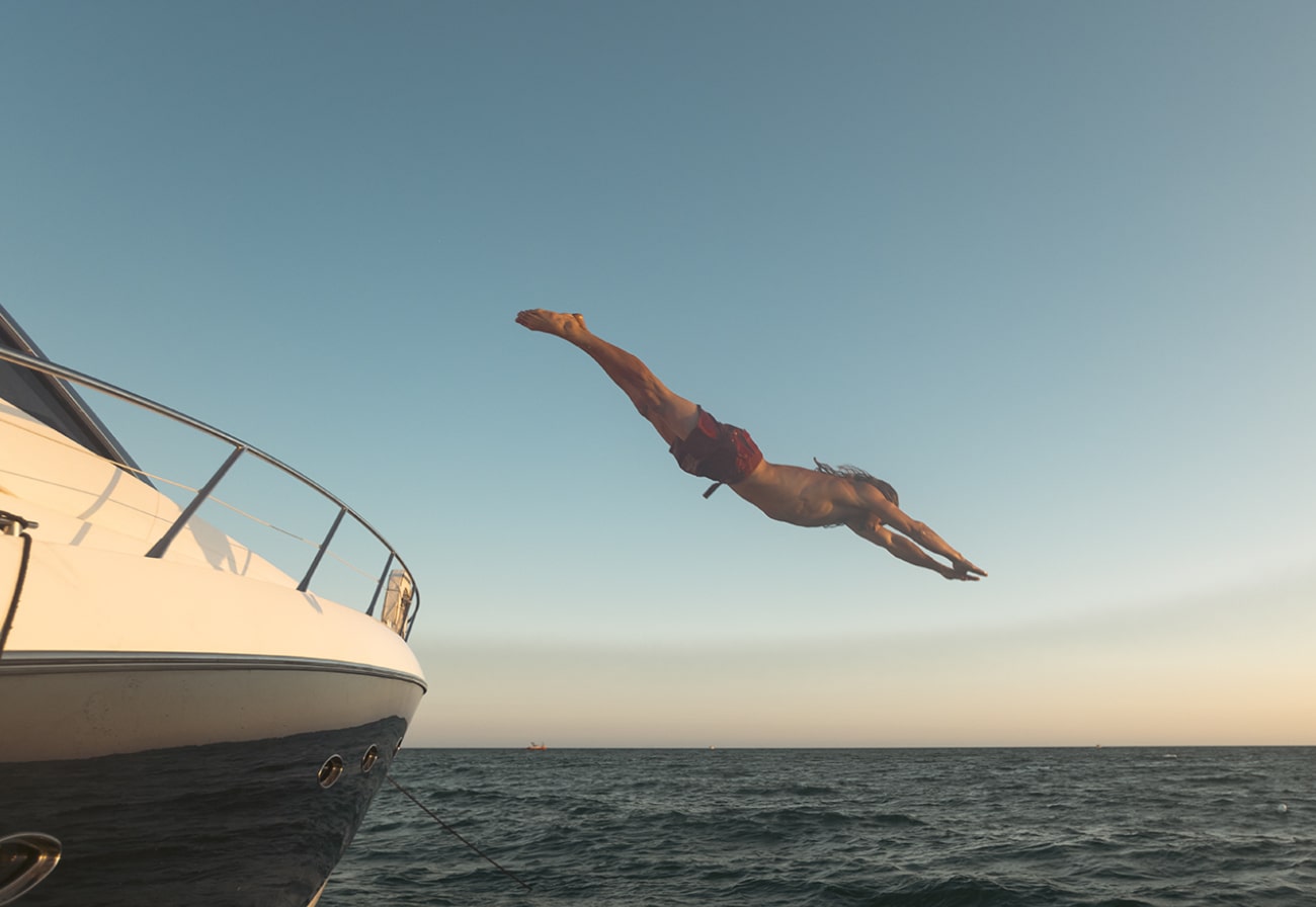 man diving from boat in vilamoura