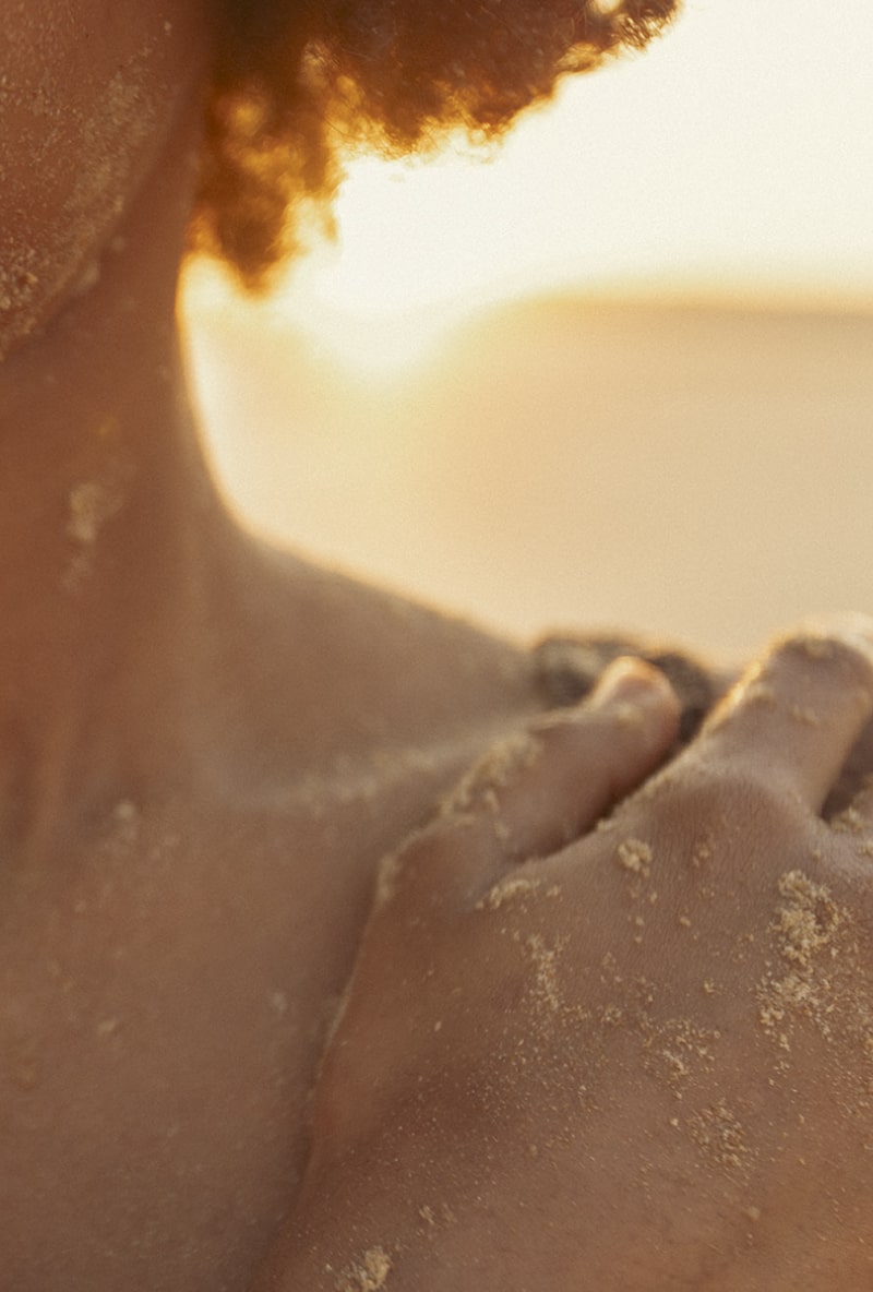 woman touching shoulder golden hour vilamoura beach